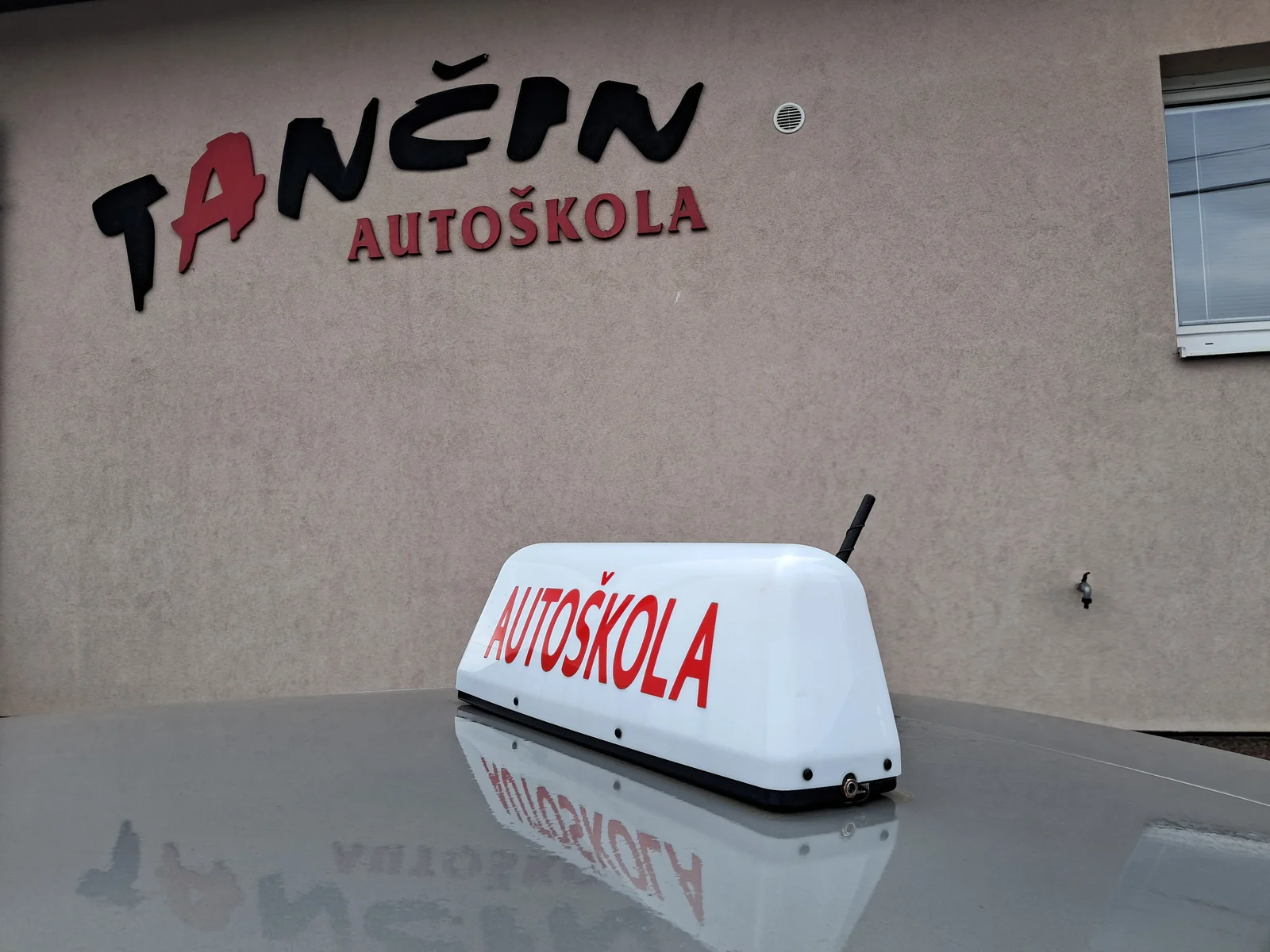 Sídlo autoškoly T v Bardejove — výcvikové vozidlo s označením Autoškola a logom Tančin Autoškola na budove